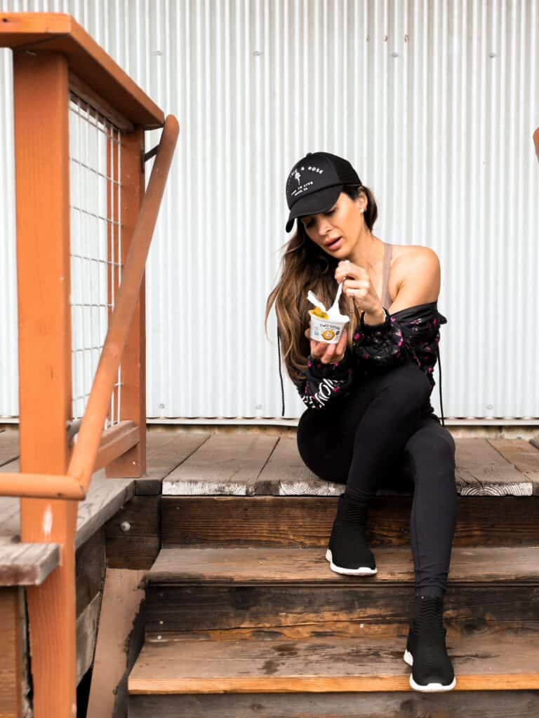 Picture of Nicole Modic from Kalejunkie sitting on steps eating lemon flavored yogurt
