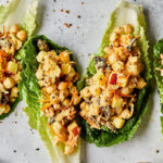 Three romaine lettuce leaves stuffed with the smashed chickpea curry salad