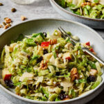 Two large bowls of the shaved Brussels sprouts salad with dijon dressing.