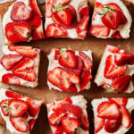 The paleo strawberry sugar cookie cake, cut into individual squares and laid out on a sheet of parchment paper