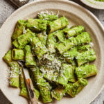 A bowl of pasta, topped with the 10 minute broccoli pesto and some parmesan cheese
