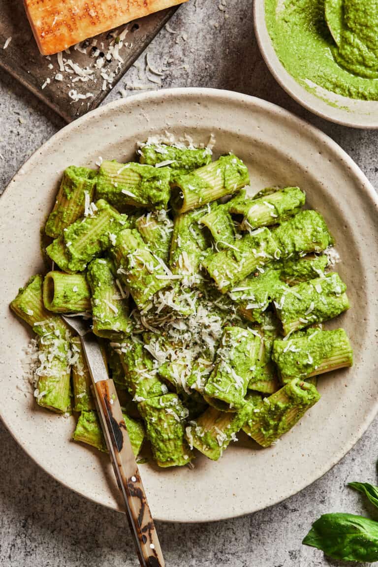 A bowl of pasta, topped with the 10 minute broccoli pesto and some parmesan cheese