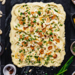 The viral butter board, sitting on a countertop, surrounded by different ingredients