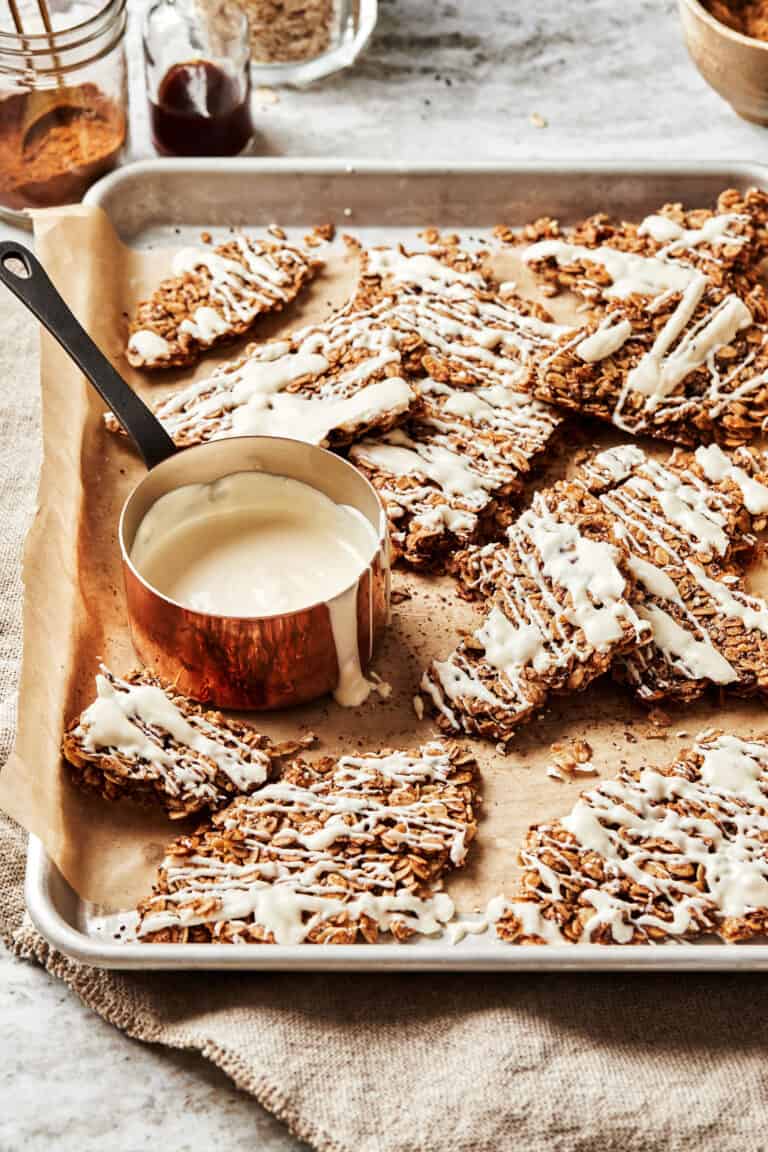 A tray of the cinnamon roll granola, with a small bowl of white chocolate on the tray.