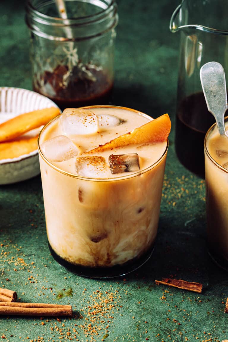 A glass of the apple crisp cold brew latte, sitting on a countertop