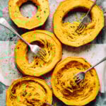 Spaghetti squash rings, laid out on a baking sheet, with a few forks twisted into them