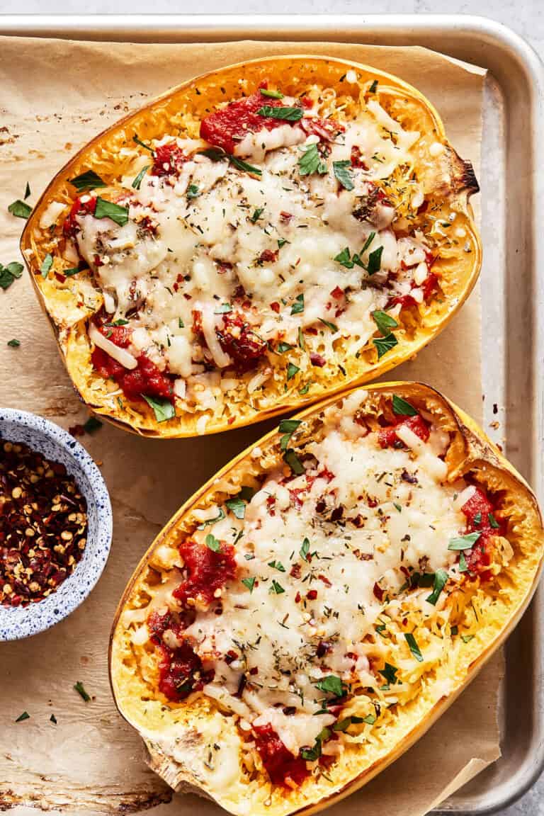 Two of the spaghetti squash pizza boats, laid out on a baking sheet