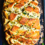A large loaf of the cheesy garlic pull-apart bread, laid out on a countertop
