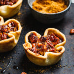 A close-up image of the mini pecan pies, sitting on a countertop
