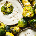 A close-up image of a plate of the Brussels sprouts with lemon tahini dressing