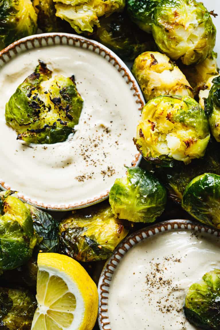A close-up image of a plate of the Brussels sprouts with lemon tahini dressing