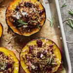 A tray of the quinoa stuffed acorn squash, laid out on a parchment lined baking sheet