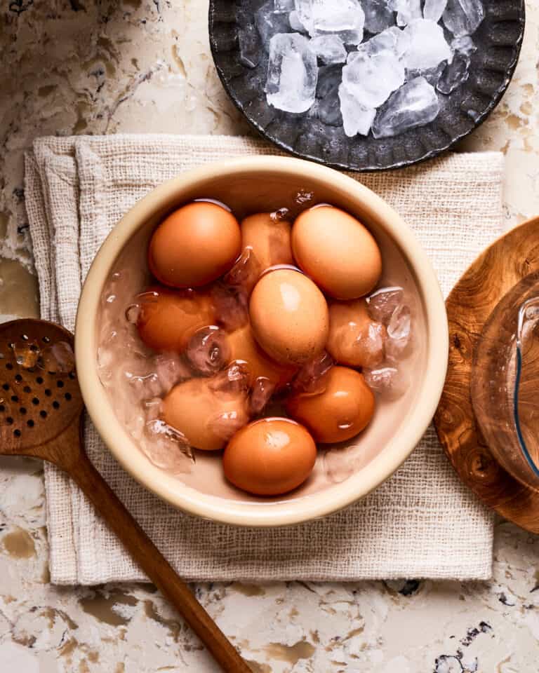 A bowl of the perfect hard boiled eggs, sitting on a countertop