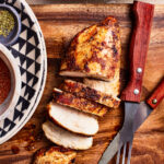 One of the perfectly juice chicken breasts, cut apart and laid out on a cutting board