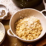 A big bowl of the pastina, with parmesan cheese actively being sprinkled on top of it