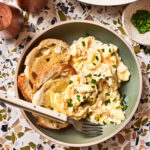 A plate of the perfect scrambled eggs, served alongside two pieces of toast