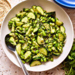 A close-up image of the cucumber edamame salad, in a bowl, with a spoon in it