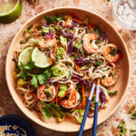 A big bowl of the healthy spring roll salad, sitting on a countertop, with a pair of chopsticks sitting inside of the bowl