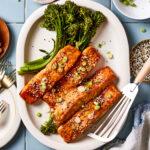 A plate of the 9 minute broiled teriyaki salmon, sitting on a plate aside some broccolini