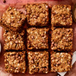 The one bowl oatmeal chocolate chip zucchini bars, sliced into squares and laid out on a sheet of parchment paper
