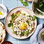 A plate with the viral crisp feta egg, sitting on a countertop surrounded by other ingredients