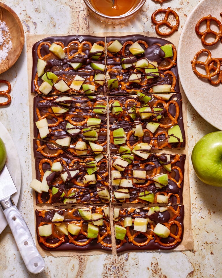 A tray of the caramel apple bark, sitting on a countertop and broken into pieces