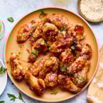 A bowl of the sticky honey garlic chicken wings, sitting on a countertop