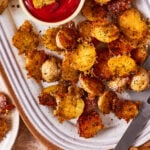 A close-up image of a bowl of the viral crispy parmesan potatoes, sitting on a countertop