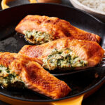 A pan, filled with the creamy spinach stuffed salmon, cooked and ready to be served