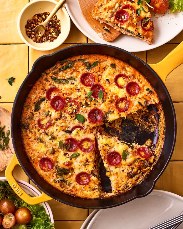 An image of the easy pizza frittata, sitting in a cast iron skillet on a countertop