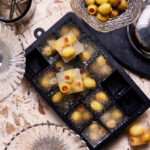 An ice cube tray, filled with the dirty martini olive cubes