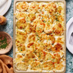 A tray of the sheet pan potatoes au gratin, siting on a countertop