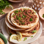 A stack of the lahmajune armenian pizzas, sitting on a plate on a countertop