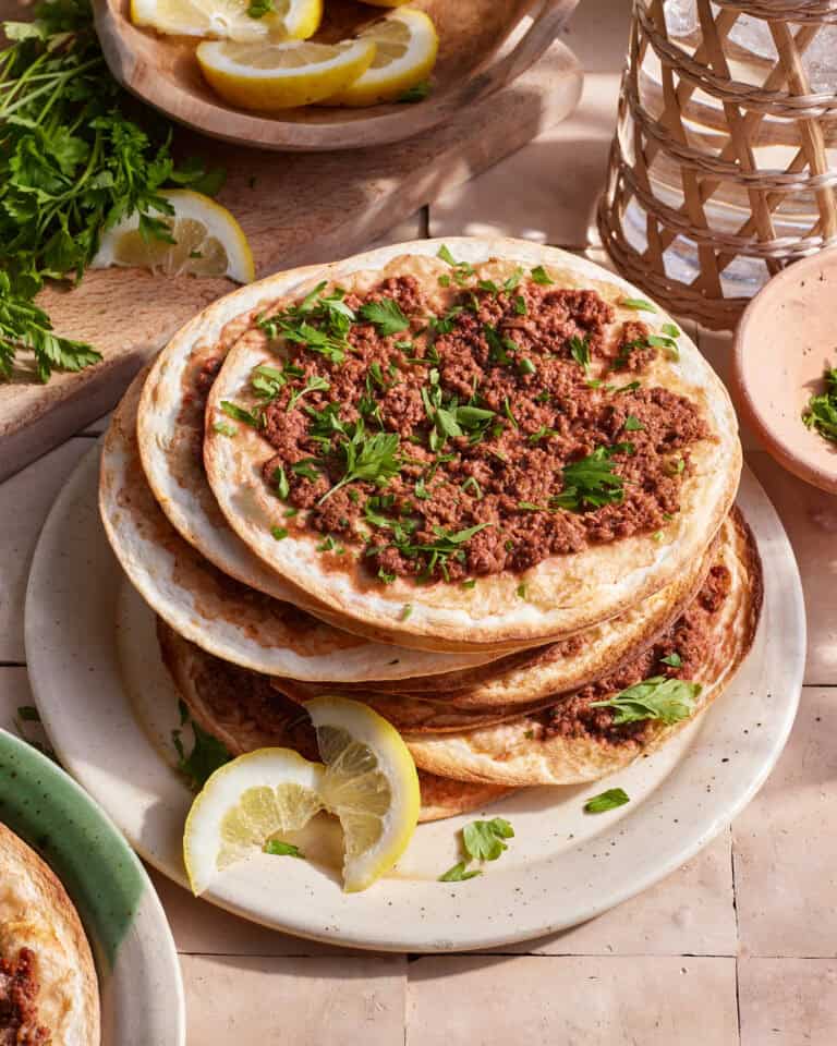 A stack of the lahmajune armenian pizzas, sitting on a plate on a countertop