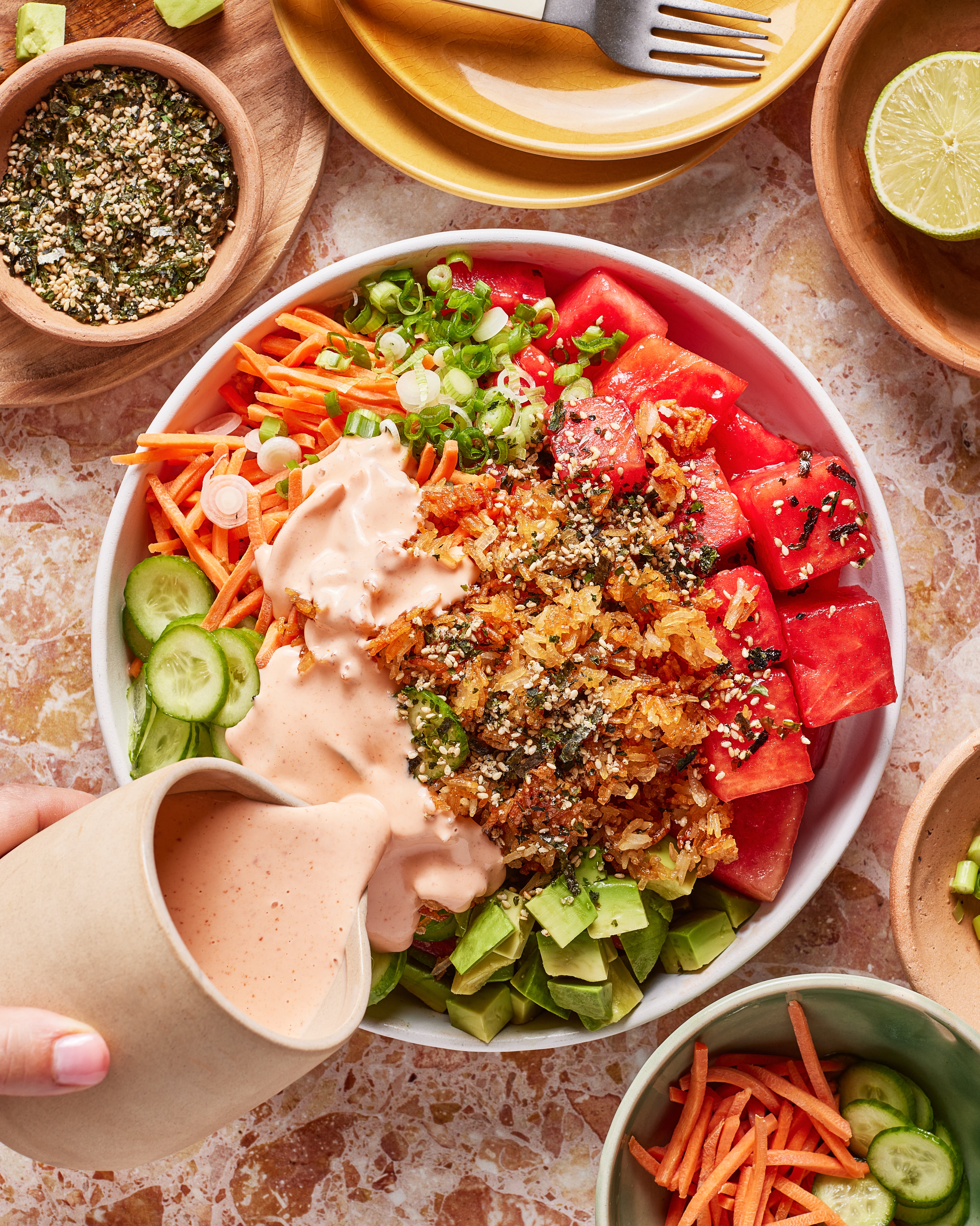 A bowl of food with sauce being poured into it.