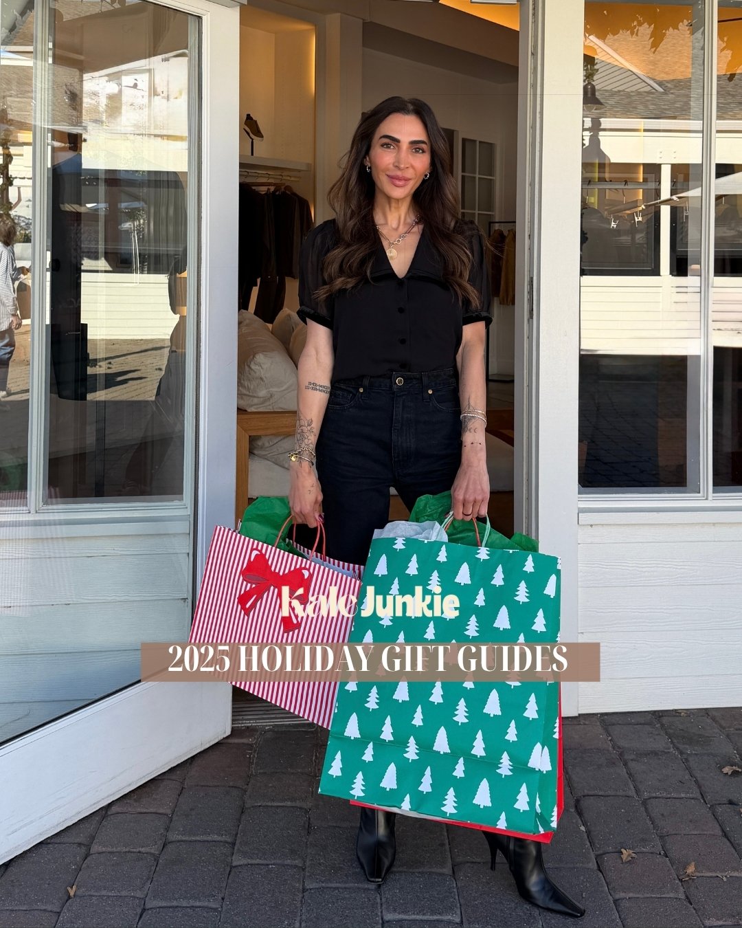 A woman stands outside a store holding two large holiday gift bags, one red-striped with a bow, and one green with white trees. Text overlay reads: "2025 Holiday Gift Guides.