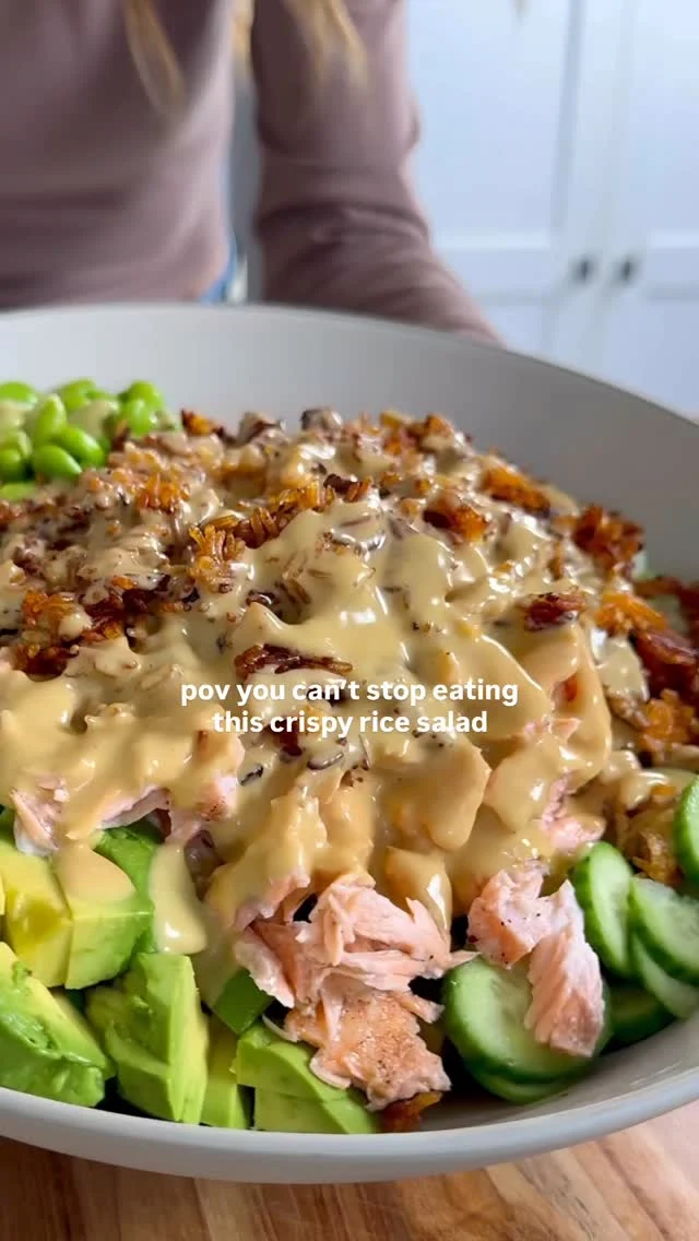 They don’t call me the crispy rice salad queen for nothing—get all 8 delivered to you by FOLLOWING me, @kalejunkie 🥬 I’m here to help you eat healthy and delicious meals like this one!

Makes 4 large servings or 6 smaller Crispy Rice
2 cups cooked rice, cooled (I used jasmine rice)
2 tsp soy sauce
2 tb chili crisp/crunch (Trader Joe’s makes a good one, I used Momofuku this time!)
1 tb sesame oil

Salmon
8oz salmon
Pinch cumin, salt & pepper

Salad
5 Persian cucumbers, thinly sliced (or 1 large English cucumber)
1 red bell pepper, diced small
1 small red onion, finely sliced 
1 avocado, diced

Creamy Lemon-Cumin Dressing
1/2 cup olive oil
1/4 cup lemon juice (1-2 lemons)
2 tb honey
1 large shallot, roughly chopped
1/2 tsp cumin
1 tsp kosher salt
1/2 tsp ground black pepper

First, prepare the crispy rice topping. Preheat oven to 400F. Line a baking sheet with parchment paper. Add cooked and cooled rice to the baking sheet. Toss well with the soy sauce, chili crisp and sesame oil. Bake for 30-35 minutes, tossing half way through (just watch to make sure it doesn’t burn). While the rice is in the oven, season salmon and place it on a baking sheet. Add to the oven (with the crispy rice) and let bake for 13-14 minutes, or until desired doneness. Remove the rice from the oven and set aside. Remove the salmon tray from the oven, shred into smaller pieces and set aside. Next, chop/slice all of the ingredients for the salad and add to a large bowl. Add the shredded salmon and crispy rice on top. Last, make the dressing. Blend to together all of the ingredients for the dressing until smooth & creamy. Taste and adjust seasonings as needed. Pour dressing over the salad. Toss and enjoy!