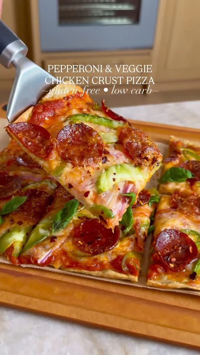 @kalejunkie 🍕 PEPPERONI & VEGGIE CHICKEN CRUST PIZZA—because sometimes the bread-free option actually tastes better, and yes, I said what I said 😏. I love a real deal pizza as much as the next person, but I sometimes just don’t feel like ending up in a food coma. So cue the chicken pizza crust and let me tell you right now, it is SO GOOD. You can top your pizza crust with what ever toppings your heart desires—I picked my personal favorites because guess who eats the food I post? ME. I do 🙋🏻‍♀️.

Comment PIZZA if you want links to anything I used in this video—food processor, pizza cutter, etc.

Makes 4 servings
1 lb ground chicken
2 eggs
3/4 cup parmesan cheese, divided
1 tb italian seasoning
1 tsp garlic powder
1/2 tsp kosher salt
1/2 tsp ground black pepper
1/3-1/2 cup pizza sauce (I love @raoshomemade)
1 cup mozzarella cheese, shredded

Toppings
15 slices pepperoni
1 bell pepper, sliced
1/2 red onion, thinly sliced
2 tb hot honey (optional)
Red chili flakes (optional)
Fresh basil (optional)

Preheat oven to 400F. Line a baking sheet with parchment paper and set aside. In a food processor, add the chicken, eggs, 1/2 cup of the parmesan, and seasonings. Pulse/process until fully combined, then spread it out onto the parchment paper. You need to be patient when working with this, as it will be sticky and that is okay! Gently press the mixture into a thin, even rectangle. Bake for 20 minutes. Remove the tray from the oven, then spread on the pizza sauce, mozzarella cheese, remaining parmesan cheese, and toppings of choice (pepperoni, bell pepper, and red onion). Place the tray back into the oven and bake for another 15 minutes. If you prefer crunchy edges, pop the pizza under the broiler for an additional 2 minutes. Remove the tray from the oven, and let cool slightly. Add pieces of fresh basil, red pepper flakes and a drizzle of hot honey. Cut into squares and enjoy! #highprotein #proteinrecipes
