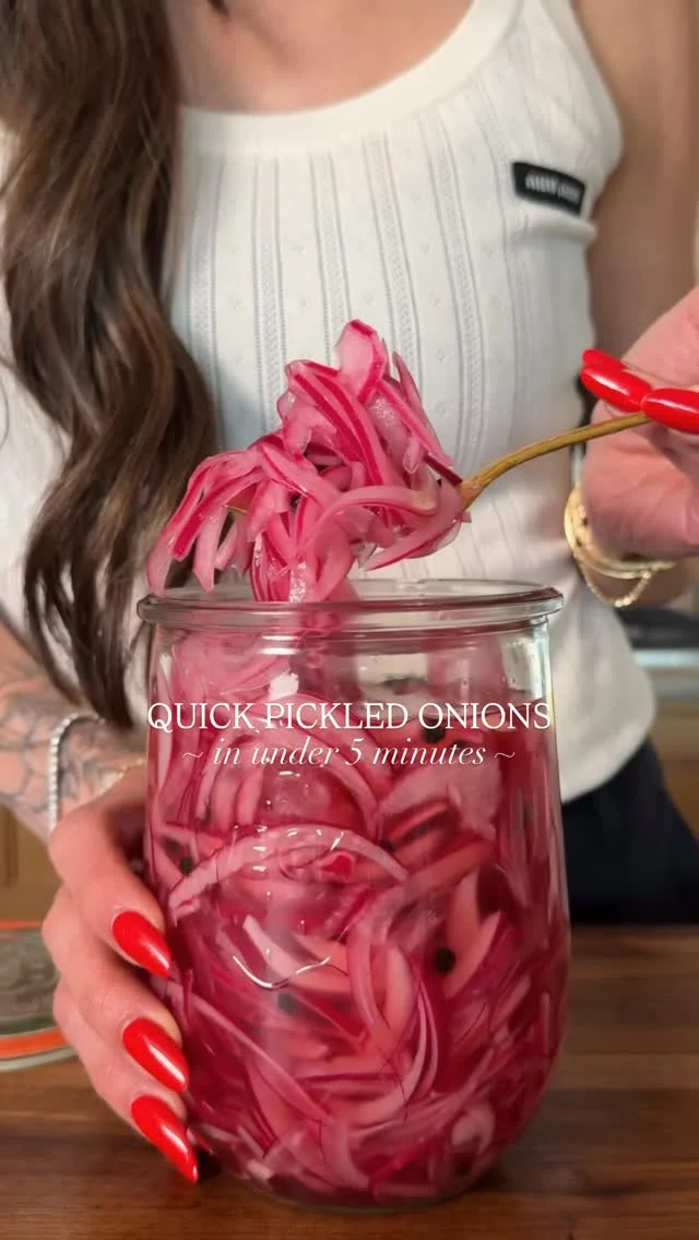 @kalejunkie’s QUICK PICKLED ONIONS! You guys have been asking, so here you go—the pickled onions I add to most of the bowls and meals I share! ☺️ It takes less than 5 min to make a big batch to enjoy all month. And, they are maple syrup sweetened instead of using cane sugar. Tangy, a little salty and simply perfect! One batch will last in the fridge for up to one month!⁣
⁣
FOLLOW my account—@kalejunkie—for easy recipes including all the ways I use these onions in my meals! 🙆🏻‍♀️⁣
⁣
2 medium red onions⁣
1 cup white vinegar ⁣
2 cups hot water⁣
2 tb maple syrup ⁣
2 tsp salt⁣
1 tb peppercorns (optional)⁣
⁣
Peel your onions and slice them very thin. I like using a mandolin to make sure they are even thickness. Place the onions into a clean jar of choice. Pour over the vinegar and warm water, then add maple syrup, salt and peppercorns (if using). Cover the jar tightly and very gently shake or turn upside down a few times so all the ingredients are all mixed together evenly. Place the jar in the fridge to set for at least 30 minutes and then enjoy! For best results and to get that deep purple color, wait a few hours or overnight and enjoy! #pickledonions #marinatedonions