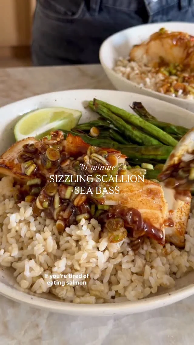 @kalejunkie my SIZZLING GINGER SCALLION SEA BASS is a 12/10 and a nice change from salmon 😏 It can also be made with cod, tilapia or any white fish. The sizzling ginger scallion sauce is packed with flavor and is so yummy over the rice! I can’t wait for you to try it :)⁣
⁣
SAVE this post, SHARE it, and FOLLOW me @kalejunkie for more easy, delicious recipes!⁣
⁣
Makes 4 servings⁣
1/4 cup low sodium soy sauce ⁣
2 tb honey⁣
1 tsp white miso paste⁣
1 1/2-2 lbs sea bass or cod or fish of choice⁣
⁣
Sizzling scallion sauce⁣
1/3 cup avocado oil⁣
2 bunches scallions, chopped finely, whites and greens in separate bowls ⁣
1 tb freshly grated ginger⁣
4 cloves garlic, minced⁣
1/4 cups low sodium soy sauce⁣
1 lime, juiced⁣
⁣
1 lb green beans, washed & trimmed ⁣
2 cups cooked brown rice⁣
Garnishes: lime wedges and chili crisp⁣
⁣
Preheat oven to 425 F. Spray a large baking sheet with cooking spray or line with parchment paper. Place the fish skin side down on one end of the baking sheet. Whisk together the soy sauce, miso and honey until combined, then brush it evenly on top of the fish, reserving some for the green beans. Next, lay the green beans in a pile on the other end of the baking sheet. Toss with the remaining sauce until evenly coated and drizzle with a touch of olive oil. Bake for 12-15 minutes until cooked through. Remove from the oven. Finally, make the sizzling scallion sauce. Heat the oil in a small saucepan over medium-high heat until tiny bubbles begin to form around the sides of the pan. While the oil is heating, mix together the white parts of the scallions, ginger and garlic in a small GLASS bowl or measuring cup (must be heat safe). Once the oil is super hot, stand back and very carefully pour it on top of the scallion mixture (it will sizzle) and gently stir to combine. Add the soy sauce and the green parts of the scallions stir to combine. Now assemble your bowls, with brown rice on the bottom, the fish, and spoon the sizzling scallion sauce on top. Add lime wedges, a spoonful of chili crisp if desired, and enjoy! ⁣