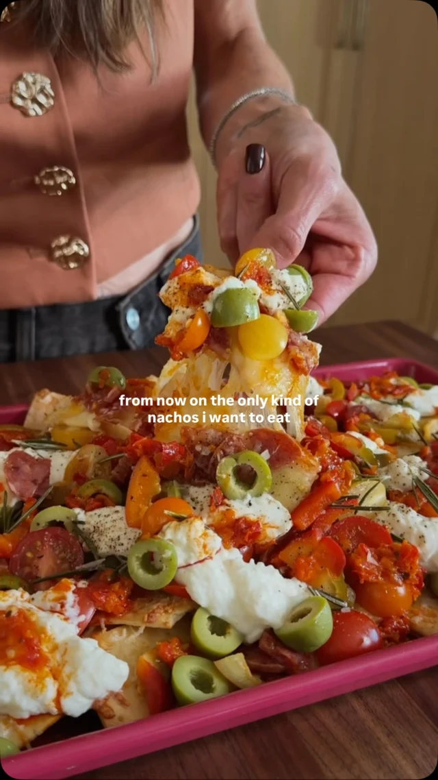 ANTIPASTO PLATTER NACHOS from my friend Cortney @cheesegal’s new cookbook Oversharing which publishes today!! 🎉 To know Cortney is to love her and she is the queen of entertaining, elevated bites, and lots of laughs. And with game day around the corner, I picked this recipe to share—it’s a little fancier than your average nachos bc sometimes you deserve fancy, and it is so easy to make!⁣
⁣
Comment LINK and I will DM you the link to her new book—you need it, yes you do! ⁣
⁣
Serves 4 to 6⁣
1(5-ounce) package Mediterranean crackers (Ilike Firehook Mediterranean baked crackers)⁣
12 ounces low-moisture mozzarella cheese, shredded or coarsely chopped⁣
1/2 cup freshly grated Parmesan cheese, plus more for serving⁣
1/2 teaspoon dried Italian seasoning⁣
1½ ounces sliced capocollo or spicy soppressata,⁣
cut into strips⁣
1 cup whole-milk ricotta cheese⁣
Kosher salt and coarsely ground black pepper⁣
1/2 cup grape tomatoes, chopped⁣
½ cup Peppadew peppers or hot cherry peppers, drained and chopped⁣
¼ cup pitted mixed Greek olives, coarsely chopped⁣
2 tablespoons chopped Calabrian chiles⁣
1 teaspoon chopped fresh rosemary⁣
⁣
Place a rack in the center of the oven and preheat to 425°F. Line a rimmed baking sheet with parchment paper. Scatter the crackers on the prepared baking sheet in an even layer. Top the crackers with the mozzarella and Parmesan. Sprinkle on the Italian seasoning, then the strips of meat. Bake the nachos until the cheese has melted and the meat has started to brown in spots, 8 to 10 minutes. Meanwhile, place the ricotta in a small bowl and season with a pinch each of salt and pepper. Top the nachos with the tomatoes, Peppadew peppers, and olives. Dollop on the seasoned ricotta. Spoon Calabrian chiles over the top, if you like, and garnish with rosemary. Serve immediately straight from the baking sheet!