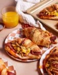 A plate of the best ever croissant breakfast sandwiches, sitting on a plate on a countertop